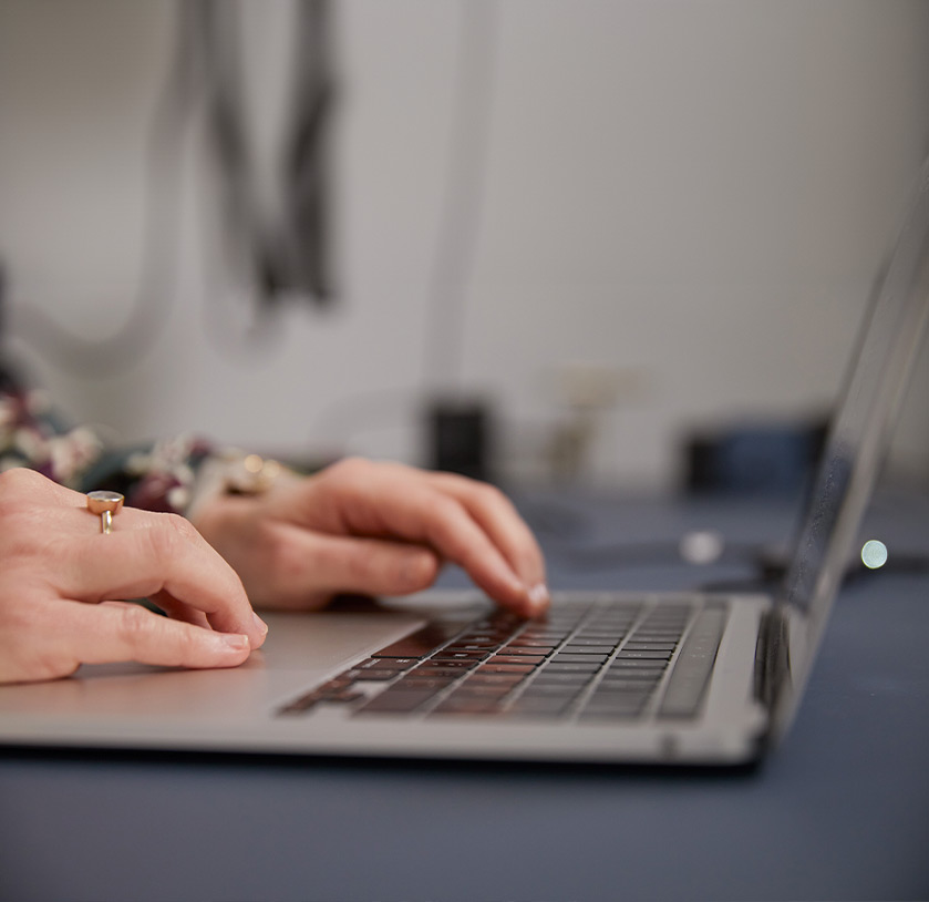 Ivana Scharf tippt etwas in eine Tastatur. Das Bild steht für das Online-Live Trauma-Kompetenz-Training.